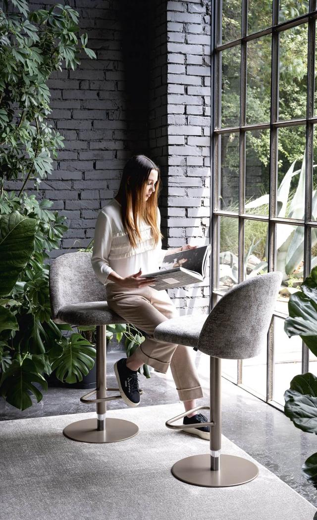 Donna legge in un angolo verde, luce naturale e atmosfera serena.