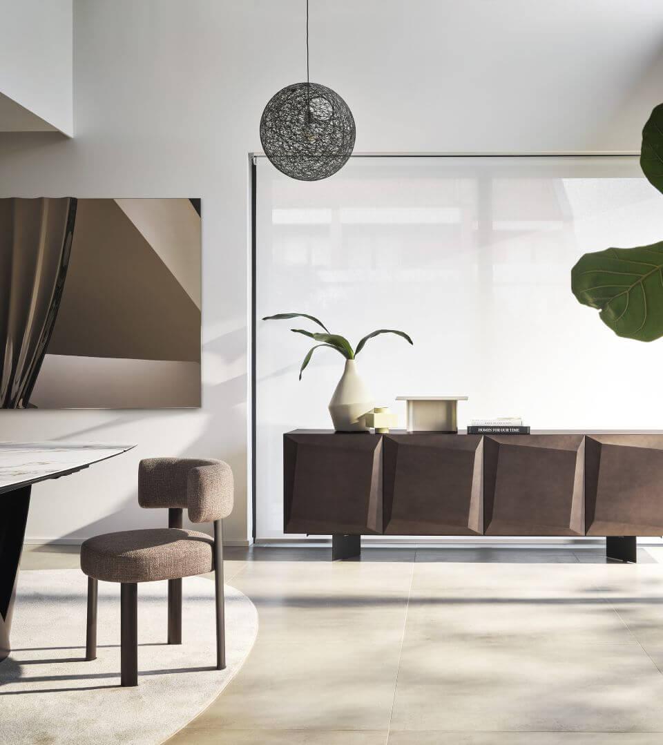 Interno moderno con sedia, credenza geometrica, lampada sospesa e pianta decorativa.